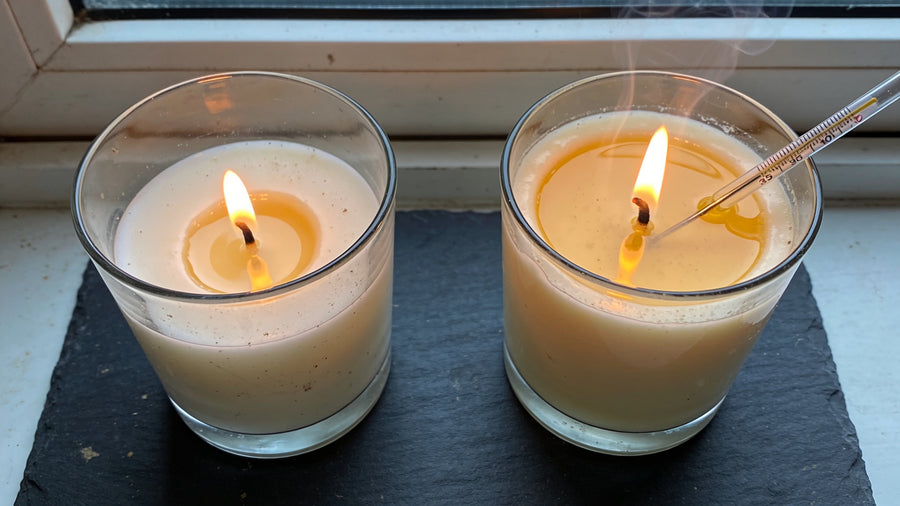 Two candles burning side by side, one with a narrow melt pool and one liquid to the glass edge